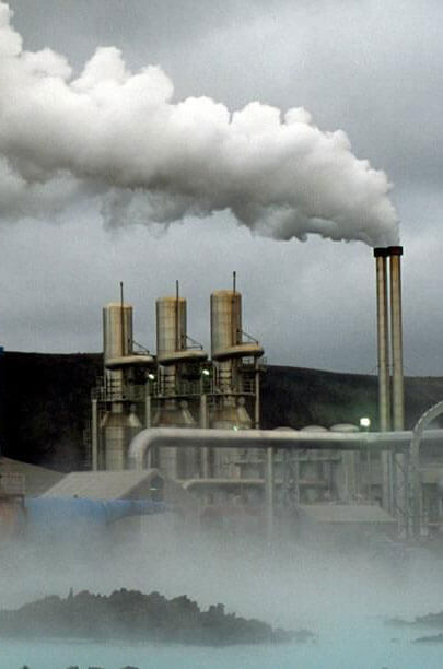 industrial factory polluting air and water with exhaust chimney and runoff into the lake