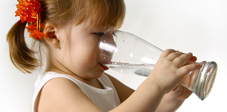 child drinking water from glass