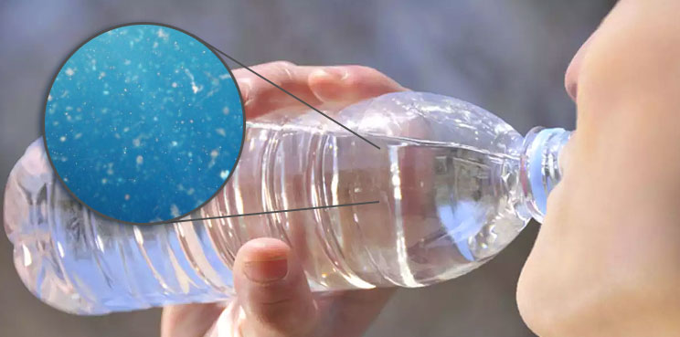 person drinking water from water bottle zoomed in view of dangerous toxic microplastics and chemicals